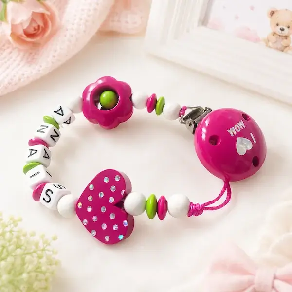 Attache tétine personnalisée en bois rose pour fille avec prénom Anais, fleur, cœur à pois et clip Love Mom