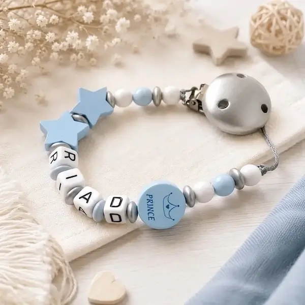 Attache tétine personnalisée en bois motif prince, perles bleu clair, blanc et argent, étoiles bleues et clip argent