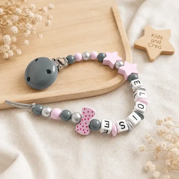 Attache tétine personnalisée rose et gris avec étoiles, nœud à pois, perles argentées et clip gris