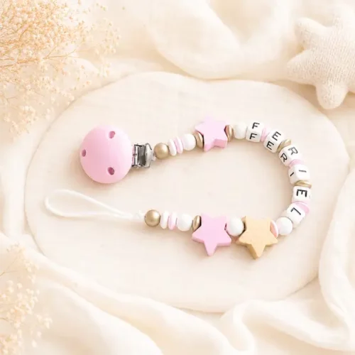 Attache tétine personnalisée Fériel rose, blanche et dorée avec étoiles et clip rose assorti.