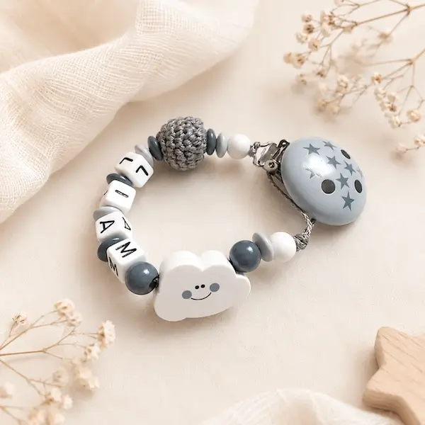 Attache tétine nuage personnalisée Liam, en gris et blanc, avec perle crochet et clip décoré d’étoiles.