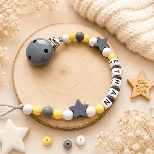 Attache tétine personnalisée jaune bois étoile avec prénom Ethan, perles blanches grises et décor naturel.