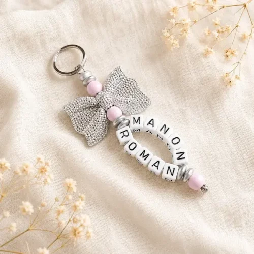 Porte-clés personnalisé avec les prénoms Manon et Roman, perles rose pâle et grand nœud argenté